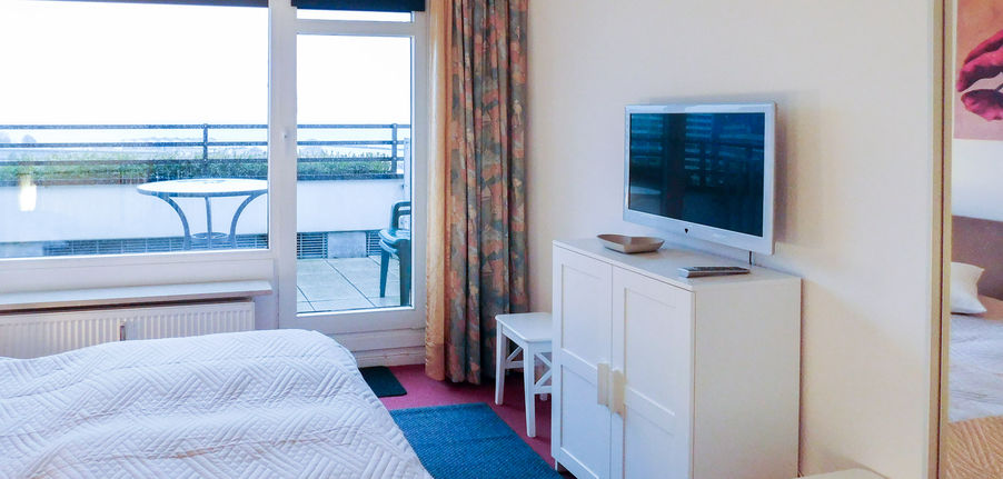 Flachbildfernseher auf einem Schrank in einem Schlafzimmer