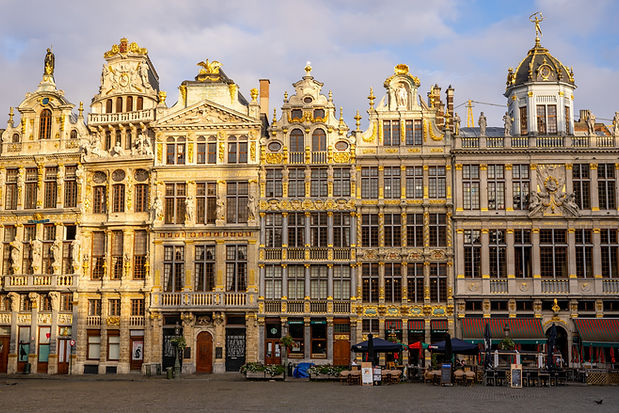 Photo de la Grande Place de Bruxelles dont les bâtiments sont illuminés par le soleil levant.
