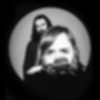 Herr und Frau Nolle, ein Paar, schauen ernst in die Kamera, während die Frau eine Kamera hält.