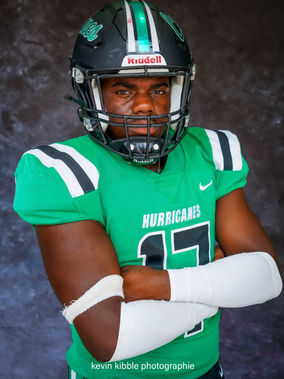 Young male football athlete in uniform and gear.