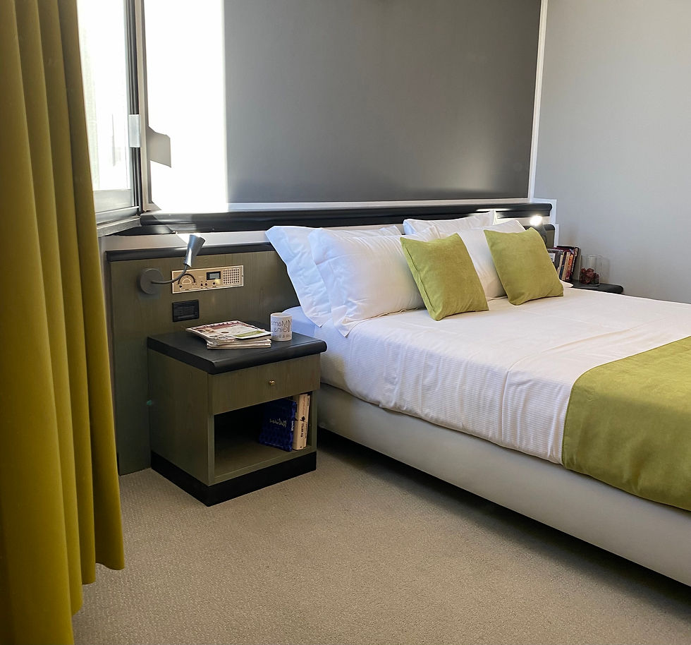 Camera d'hotel con letto matrimoniale con lenzuola bianche e runner verde acido