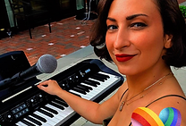 Sylvana Joyce cinematic rock performer playing keyboard during live performance for venues and events