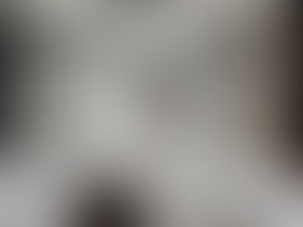 Spacious room with white and beige curtains, marble floor, and recessed lighting. A dark, oval table is partially visible. Calm ambiance.