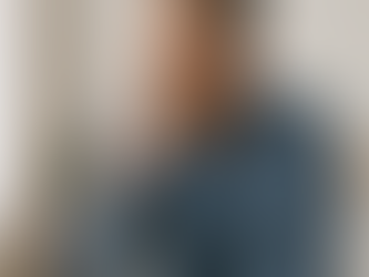 iddle-aged man sitting thoughtfully indoors, symbolizing personal questions about prostate and sexual health