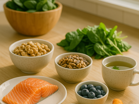 Healthy food on a wooden table: salmon, nuts, blueberries, turmeric, tea, spinach in bowl near window. Bright, fresh, natural setting.