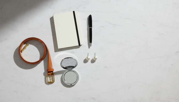 Overhead view of simple accessories arranged beside a notebook.