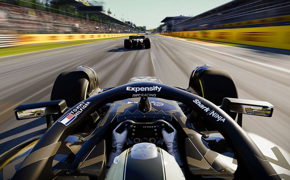 Driving POV from a racing car, pursuing another on a track. Branding seen: Expensify, Tommy Hilfiger. Blurred grandstand and trees.