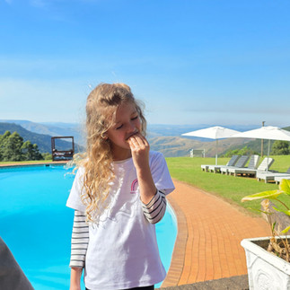 Eating smores with pool and mountain backdrop and blue skies