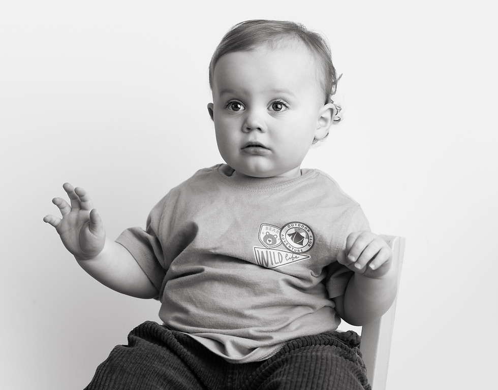 Black and white personality child portrait photography of a toddler sitting on a chair