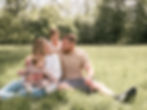 Outdoor newborn and family photography session in a field.