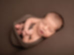 Sleeping baby in brown wrap for newborn photography