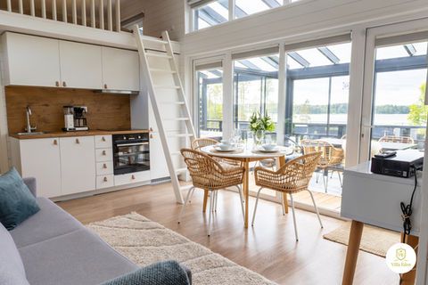 Kuva Villa Edenin olohuoneesta, jossa toisen parven eteen on asennettu valkoiset tikkaat."