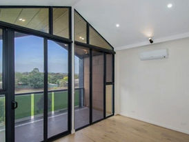 Empty room with split system air conditioner, large glass doors, balcony, and scenic view