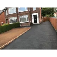 A long driveway outside of a house with new paving.