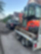 A digger being towed by a 4X4.