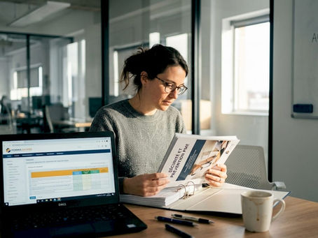 Le responsable santé et sécurité en entreprise contrôle les dossiers et documents dans son bureau au sein d’une PME.