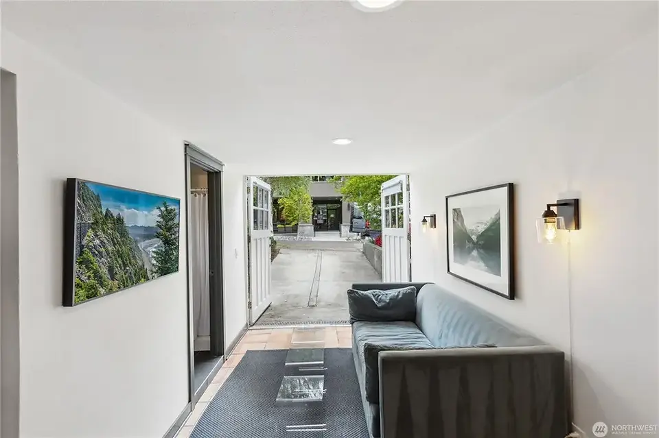 Seattle's "Spite House" interior with open garage door showing a driveway and neighboring buildings.