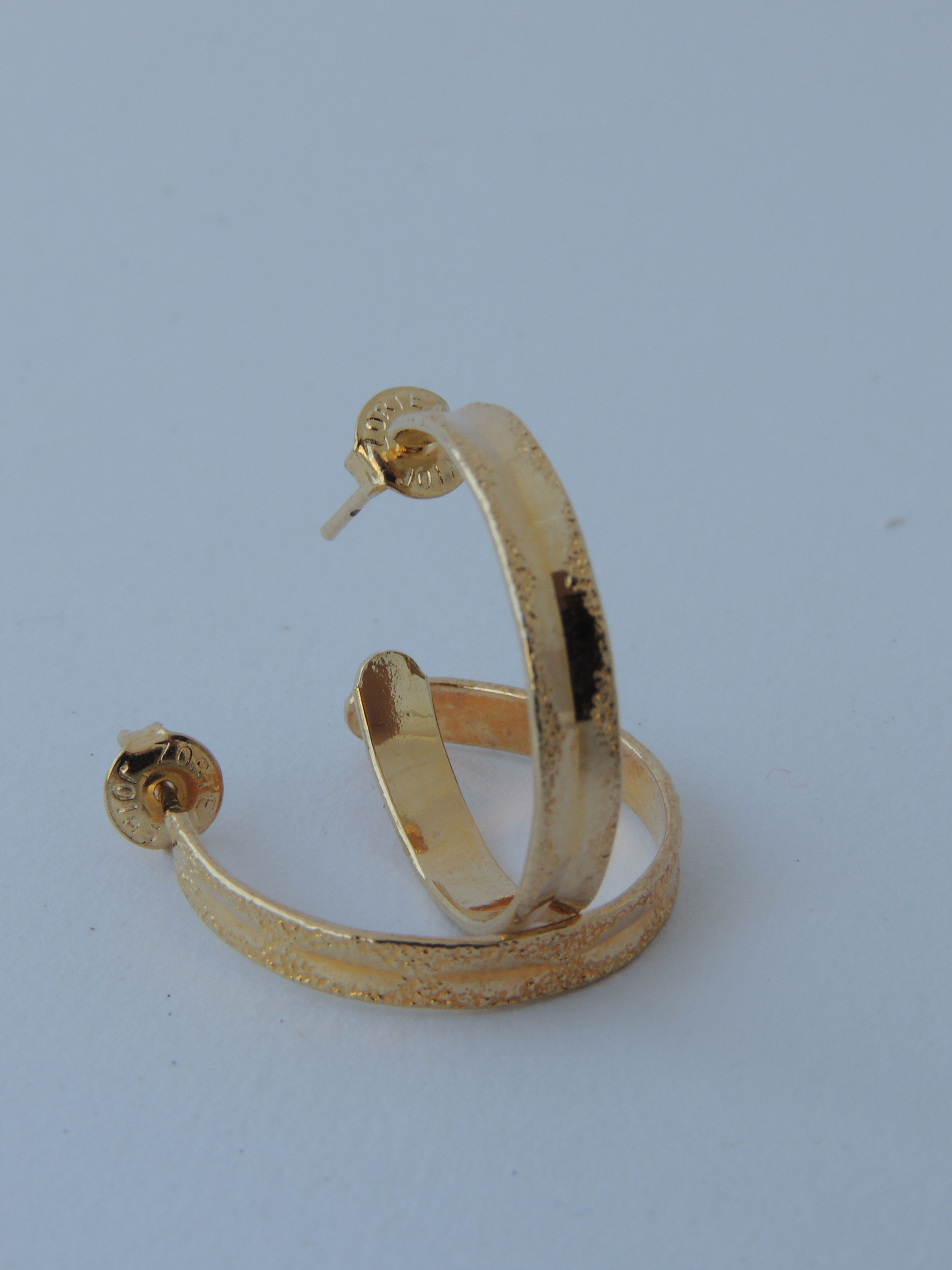 Brinco argola média com detalhes martelado. Folheado em ouro 18k