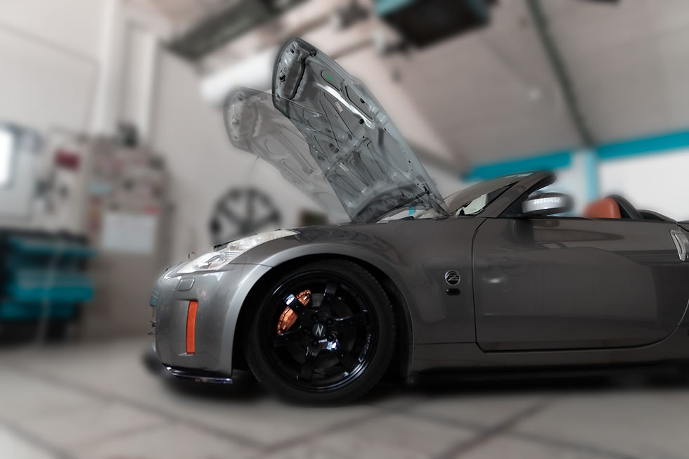 Seitlicher Blick auf einen silbernen Nissan 350Z, dessen Motorhaube aufgeklappt ist und schwach visualisiert geschlossener.