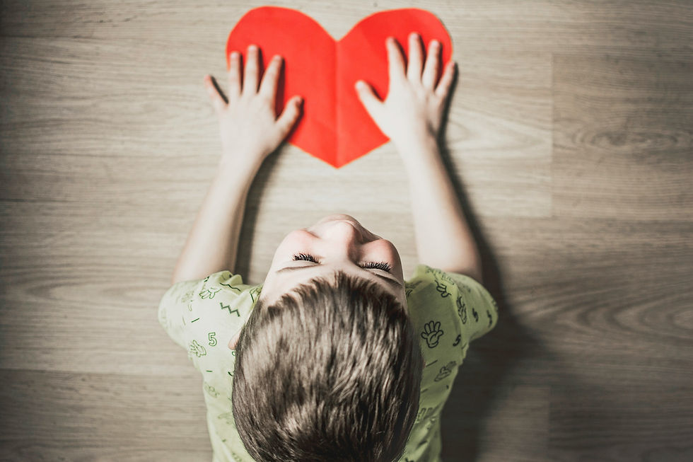 ASD child holding heart paper cut out