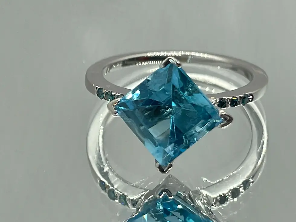 Custom 18K white gold ring with princess-cut blue topaz and natural blue diamonds. Luxurious handmade jewelry with gemstones