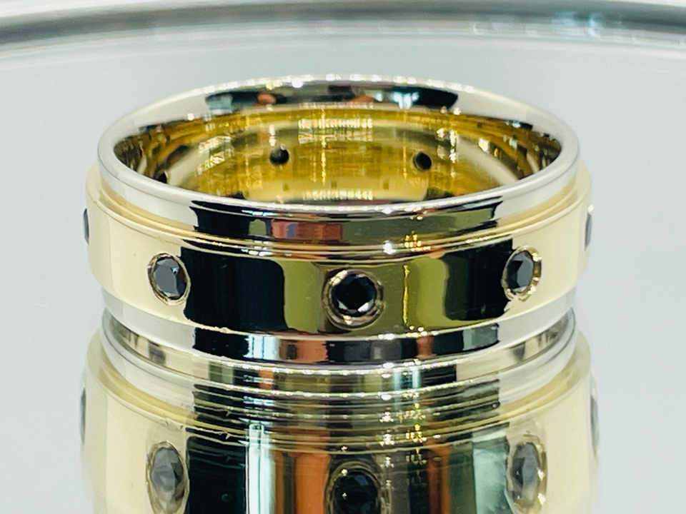 Men's wedding band in 14-carat white and yellow gold with black diamonds, custom luxury handmade jewelry.