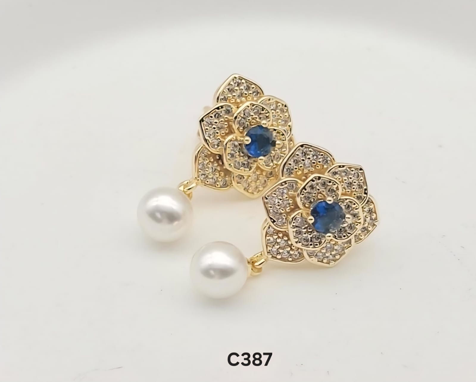 Aritos laminado de oro 18k en diseño de flor con centro de piedra azul