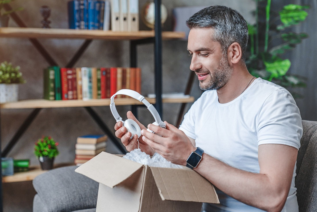 Man opening a package holding a wireless headset.jpg
