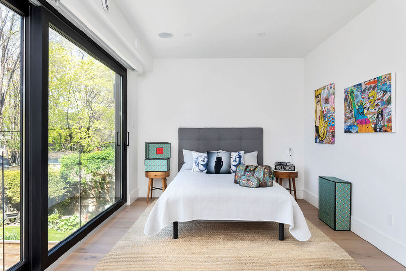 Bedroom with floor to ceiling windows and backyard view in Etobicoke custom home