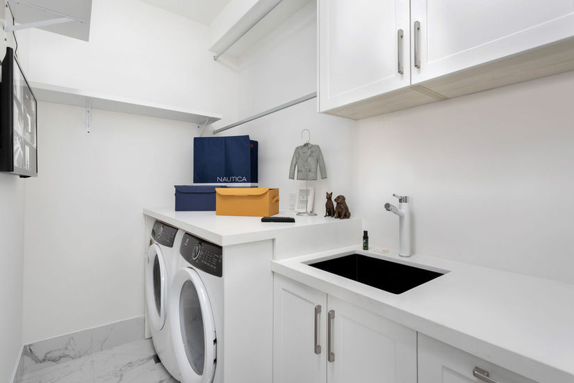 Luxury laundry room with built in cabinets in Etobicoke custom home