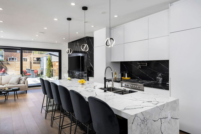 Open concept kitchen and living room with quartz island in Etobicoke custom home