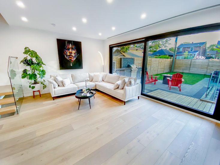 Living room with large sliding doors leading to backyard in Etobicoke custom home