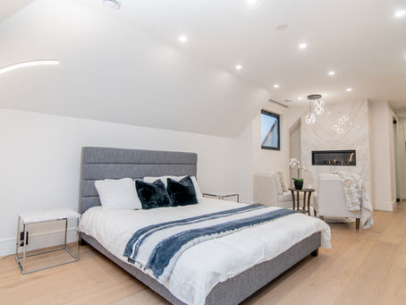 Toronto attic renovation converted into a bright primary bedroom suite with upgraded insulation, windows, finished ceilings, and custom interior detailing.