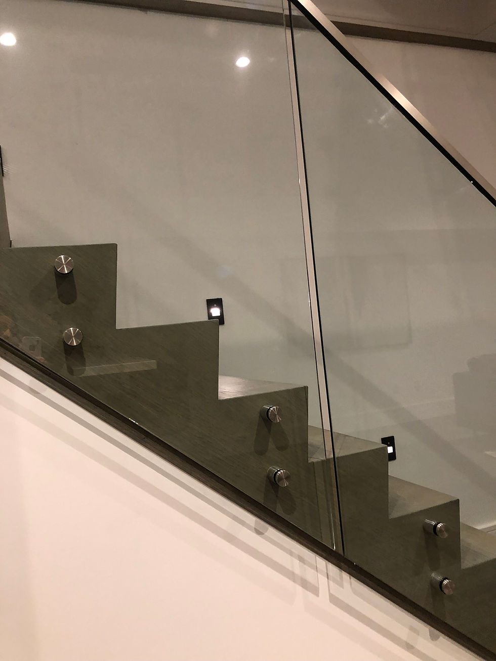 Side-mounted glass staircase railing by 416 Construction creating an open, contemporary interior.