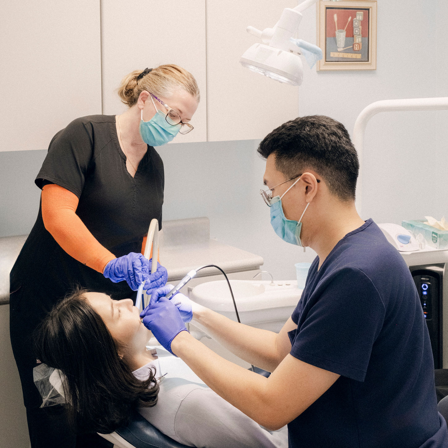 Dentist and assistant treating patient