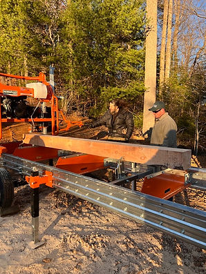 Two men using portable sawmill