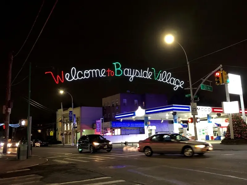 Nightime image of Welcome to Bayside Village sign over Bell Blvd.at nightimage