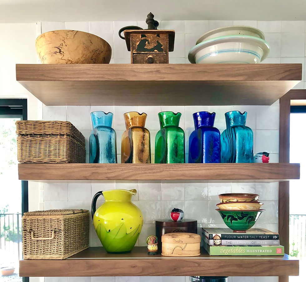 Pair of white floating shelves displaying houseplants and framed artwork