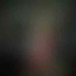 Gnome with ginger and green hair. Tall hat that is green, gold, and orange in colour.