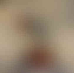 Gnome with long ginger and brown hair and a tall hat with green, brown and white felt