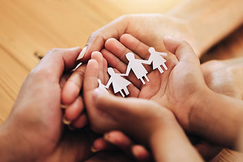 hands-holding-paper-cutout-family-on-wooden-surfac-2026-01-09-10-49-49-utc.jpg