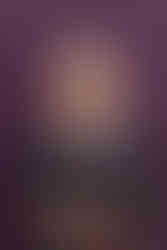 White woman in patterned top smiling in front of purple wall Professional headshots Brighton