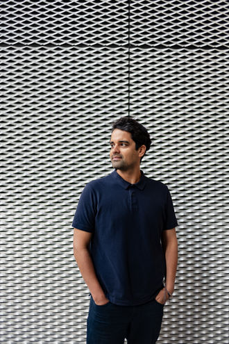 man  in front of metal wall
