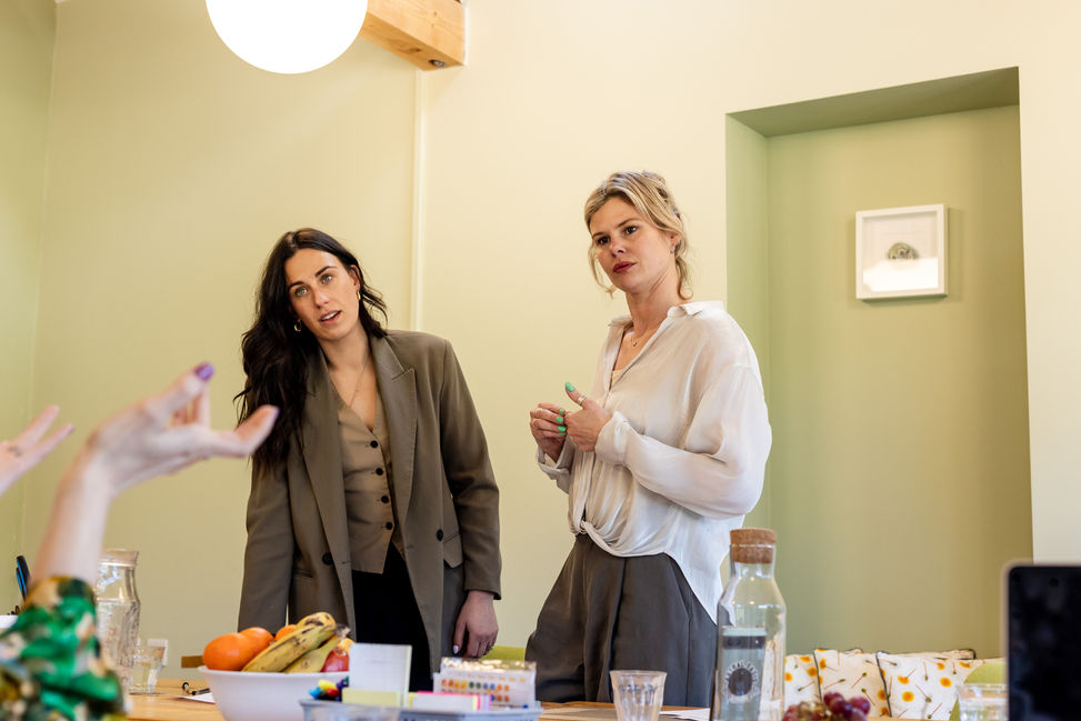 two women in a meeting listening to a colleague who is out of shot Brighton business photography
