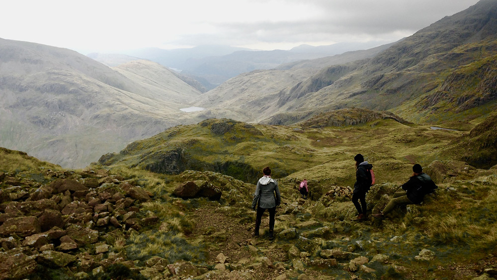 Mountain view over Eskdale with three walkers in foreground