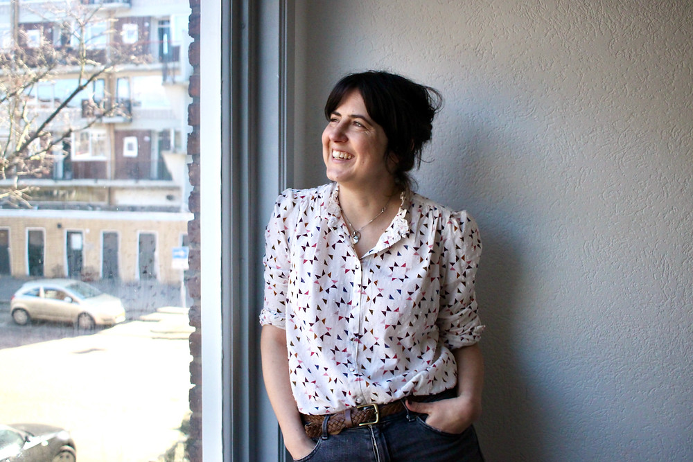 Women in white shirt smiling and looking out of window