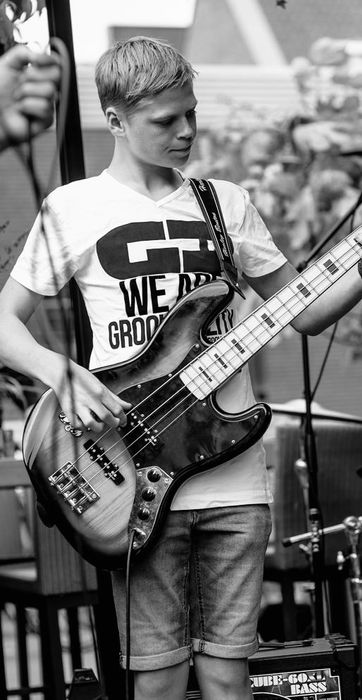 Basleerling Fender speelt basgitaar