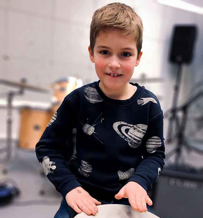 leerling speelt djembé tijdens muziekles
