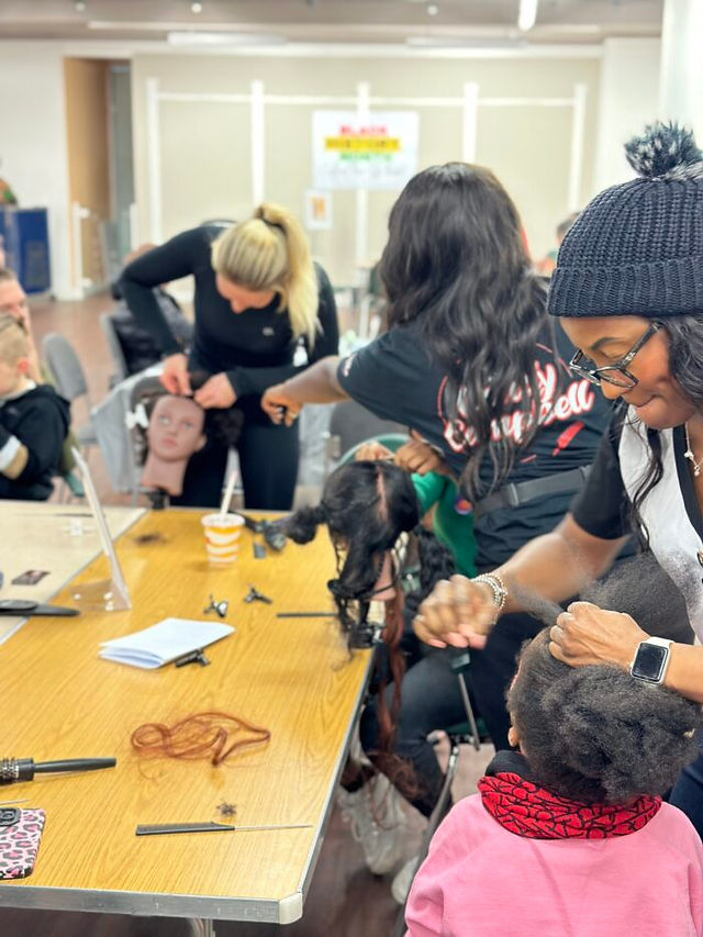 a group of young women learn how to braid hair in a hair braiding workshop