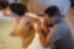 a partner cupping hands with birthing person in labor pool at home birh in arizona